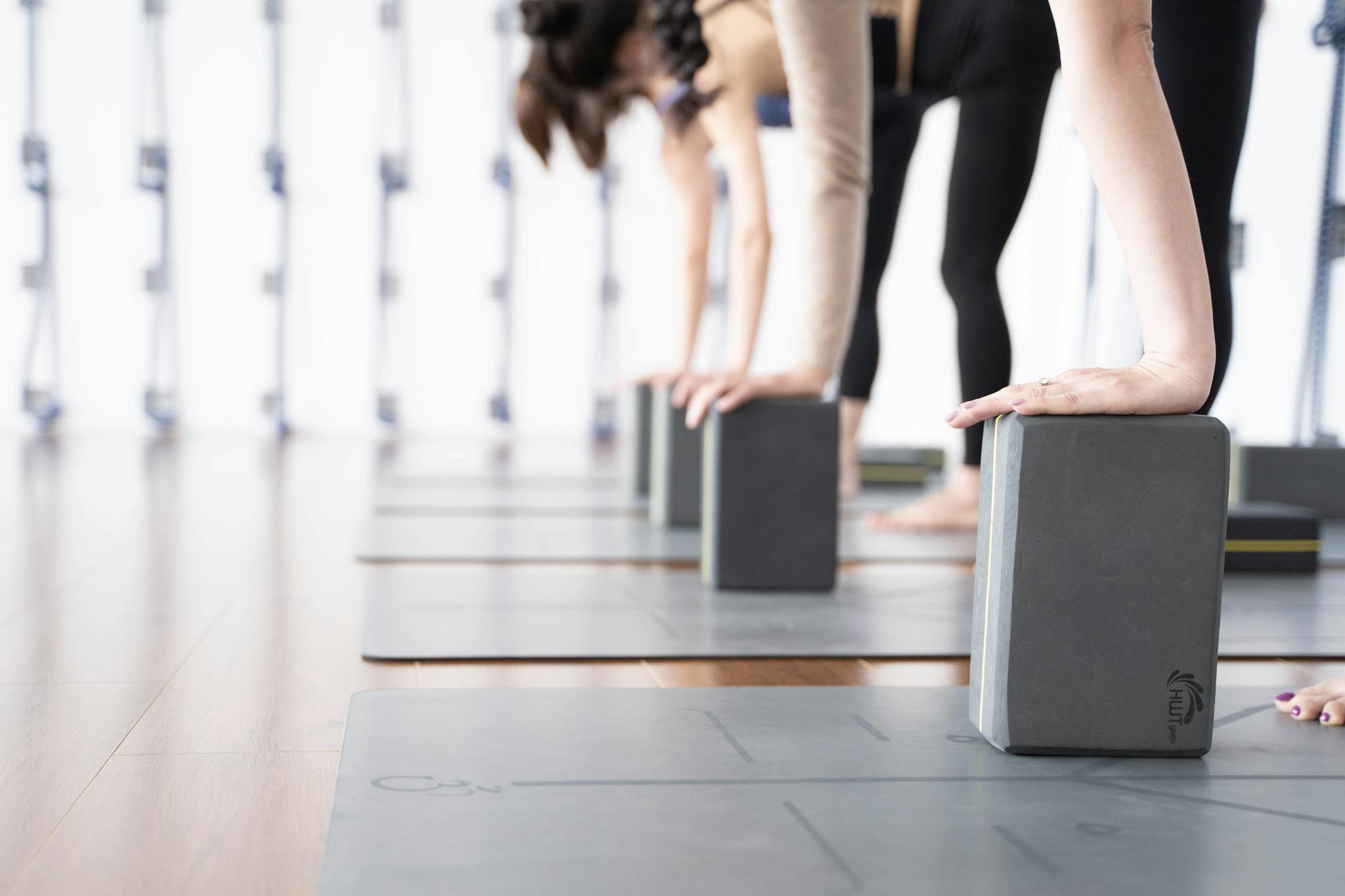 A group of women practicing yoga using blocks in a bright studio setting.